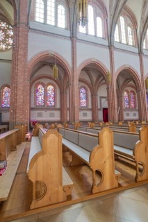 Interior of church with light wooden benches and colorful glass windows in Gothic style, Sacred