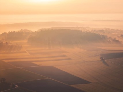 Wide, misty landscape with softly lit hills and fields at sunrise, Gechingen, Calw district,