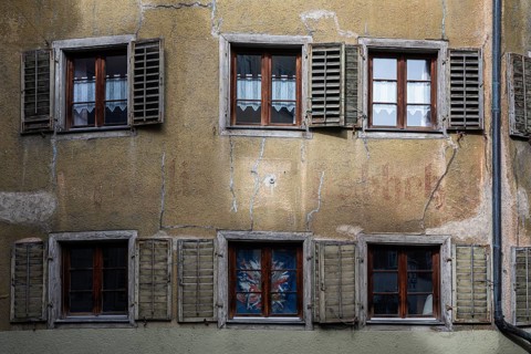An old, dilapidated, dilapidated residential building, apartment building with shutters in the