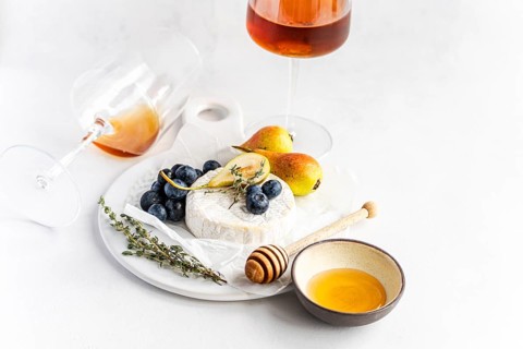 Elegant still life featuring creamy brie cheese, ripe blueberries, and juicy pears, complemented by