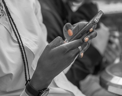 Hands of a colored woman with cell phone, black and white, Paris, France
