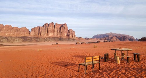 A serene view captures the essence of Wadi Rum in Jordan with its sprawling red sand and monumental
