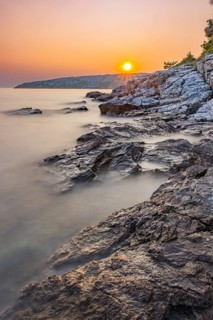 Sunset over crystal clear water on the beach of Ustrine Bay on the island of Cres, long exposure,