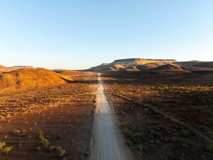 Aerial view, infinite space, straight road leads through dry desert landscape, hills in Damaraland,