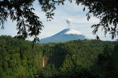 This picturesque landscape captures Kaspa Biru Waterfall majestic peak shrouded in clouds,