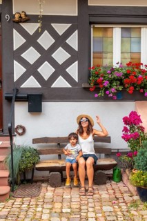 Mother and son sitting in medieval village in old town Gengenbach in Black Forest, Germany, family