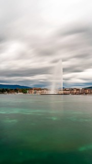 Long exposure shot of Geneva's Jet d'Eau, spectacularly soaring into the sky against a moody