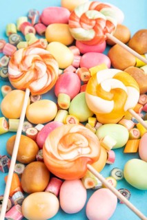 Various caramel candies on blue pastel background. close up, side view