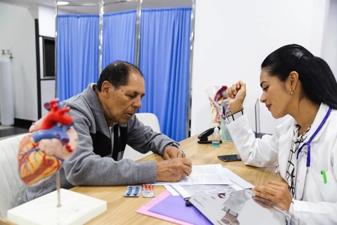 Elderly male patient receiving attentive care from a young female doctor in a Latin American