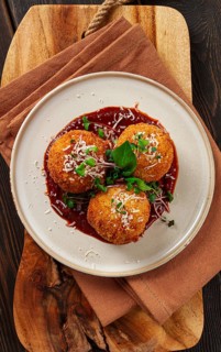 Crispy Arancini appetizer, with parmesan cheese and microgreens, plate, tomato sauce, homemade, no
