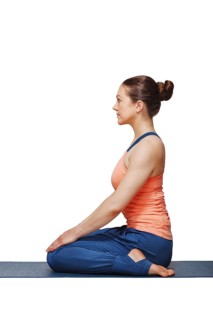Woman in Hatha yoga asana Vajrasana, vajra pose or diamond pose