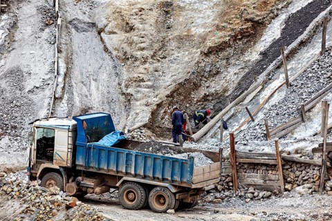 Workers and trucks mining and loading rubble in a mountainous area, The Potosi silver mines on