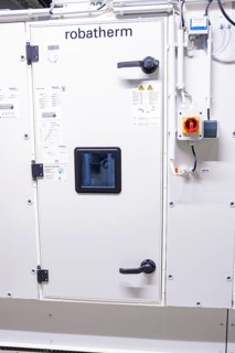 Detailed view of a white control cabinet door in an industrial environment, ventilation system,