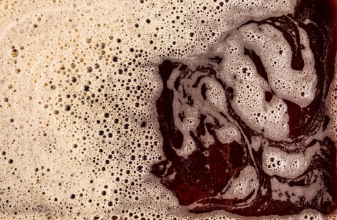 A detailed macro shot showcasing the rich texture of foamy coffee, highlighting its bubbly