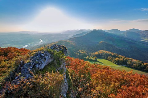 View of an autumnal forest from the Gisliflue, behind the Jura foothills with Wasserfluh and