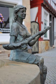 Broomwoman sculpture by Ewald Rumpf 2006, modern art, bronze sculpture, life-size, sitting woman