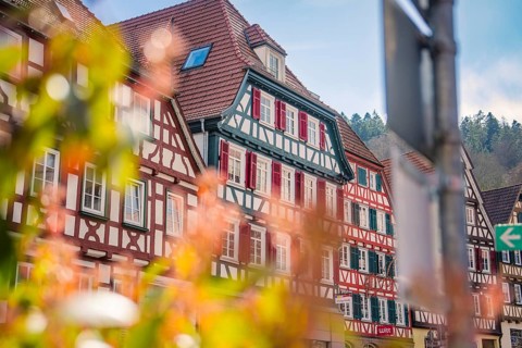 Half-timbered houses with red shutters in the sunny old town, Calw, Black Forest, Germany