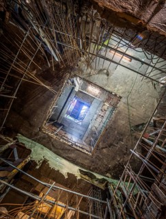 View of a building under construction, showcasing exposed frameworks, steel reinforcements, and raw