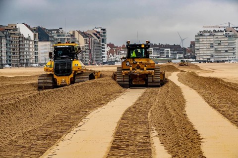 Bulldozers when distributing sand on the beach in the town of Knokke-Heist, part of coastal