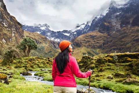 An Ecuadorian woman enjoys a breathtaking hike near El Altar volcano in the Andes. She stands amid