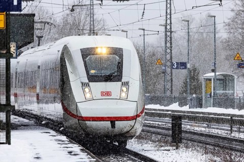 ICE traveling through a winter landscape in snowfall. A train on the line in the Deutsche Bahn
