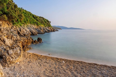 Crystal clear and turquoise water on the beach of Ustrine Bay on a sunny day at sunset on the