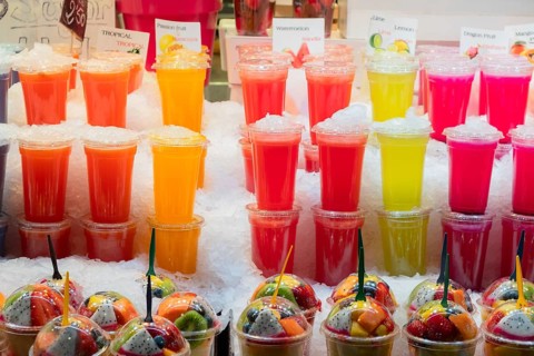 Smoothies and plastic fruit containers at La Boqueria market in Barcelona, Spain