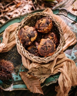 A rustic wicker basket filled with freshly baked pumpkin muffins, placed on an intricately