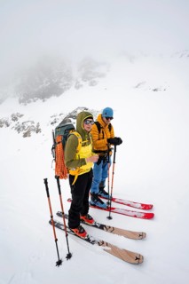 Two ski tourers taking a break, looking for a good ascent route, ski tourers in a wintry mountain