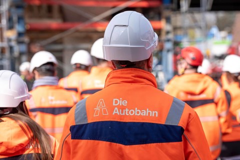 Autobahn GmbH employees wearing glowing protective clothing and safety helmet, on a construction