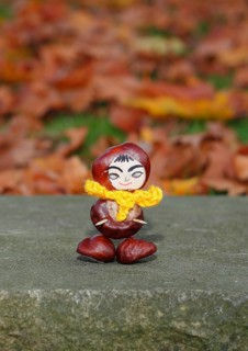 Funny chestnut figure with yellow scarf on a wall, North Rhine-Westphalia, Germany