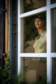 Bust of a mannequin, figure, doll of a woman, fashion doll, looking out of window, smiling,