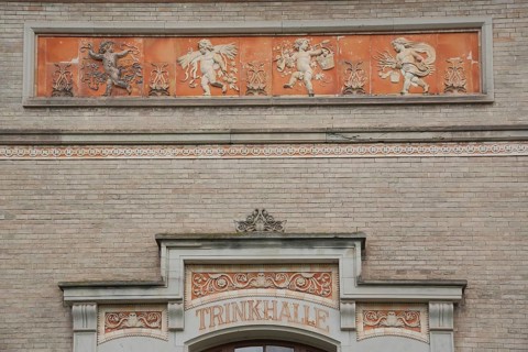 Side entrance with ornaments and reliefs, cherubs, inscription, detail, drinking hall, Wandelhalle,