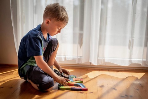 5-6 old boy play with blocks puzzle
