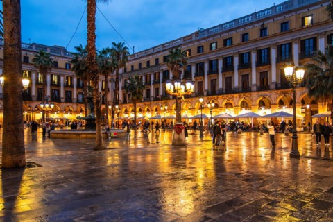 Nightlife at Plaça Reial, lanterns by Gaudi in the historic centre of Barcelona, Spain