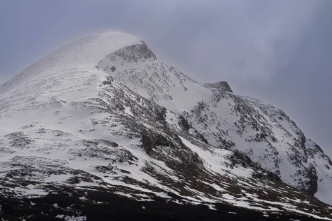 Snow-capped mountain peak with snowwoods and rocky ridge, fog at the summit, Andes, Tierra del
