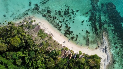 Aerial view capturing a stunning beach scene in the Philippines with tourists enjoying the pristine