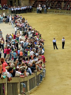 Il Palio di Siena, historical horse race, audience on the square behind barriers, policemen
