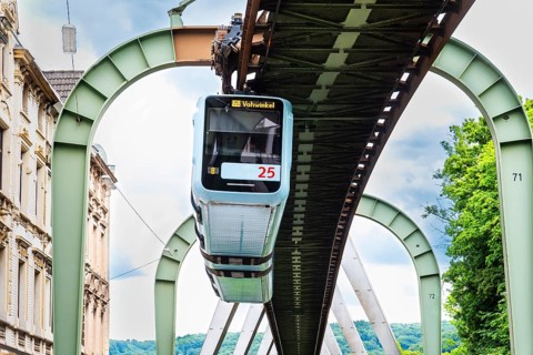The Wuppertal suspension railway runs through Vohwinkel in front of buildings from the Wilhelminian