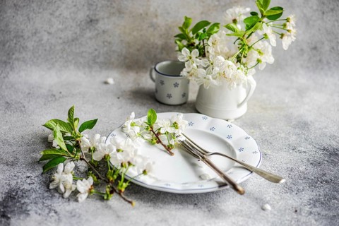 An elegant dining scene featuring a white plate adorned with delicate flowers, a fork, and a knife.