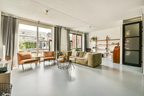 A stylish and inviting modern living room featuring a cozy seating arrangement, natural light, and