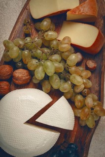 Georgian cheese, Imeretian and smoked suluguni, grapes, nuts, on a cutting board, Georgian cuisine,
