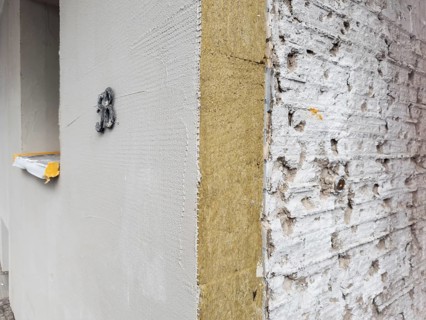 The façade of an apartment building is being energetically renovated with mineral wool insulation