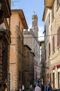 Visual axis through a narrow alley to the Palazzo dei Priori on the main square of Volterra,