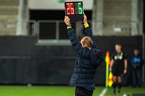 Team manager man shows players substitution during football match in Lubin, Poland