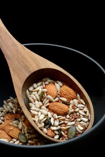Kernels in ladle, kernel mix of almond kernels, sunflower seeds, linseeds and pumpkin seeds
