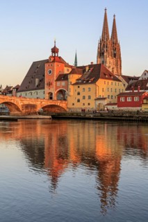 Church and bridge reflected in river, evening light, sunny, idyllic, Regensburg Cathedral and stone