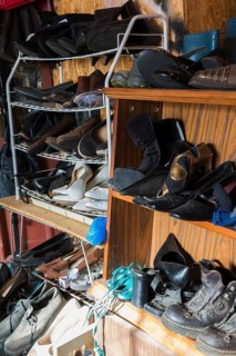Racks with old men's and woman's shoes for sale inside second hand goods and chattels store,