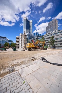 Construction site for the demolition of a building with hydraulic excavator CAT 374F under a blue