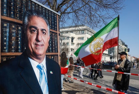 Iran demo for the end of the Islamist mullah regime in Iran, a man standing with a large historic